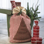 Hæklet julesæk med lodrette striber og grantræ på forsiden